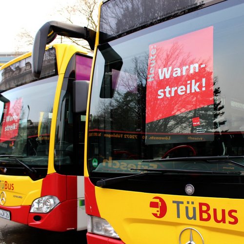 Warnstreik!" sowie das Logo der Gewerkschaft ver.di. Im Hintergrund sind Bäume und ein Gebäude zu sehen.