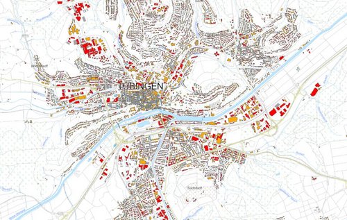 Eine detaillierte Übersichtskarte von Tübingen, Deutschland. Die Karte zeigt verschiedene Stadtteile mit rot und gelb markierten Gebäuden, die vermutlich unterschiedliche Nutzungen oder Zonen repräsentieren. Ein Fluss verläuft durch die Stadtmitte, und es sind Straßen, Wege sowie umliegende Grünflächen sichtbar. Norden ist in der oberen Bildhälfte, während die Stadtmitte hervorgehoben wird.